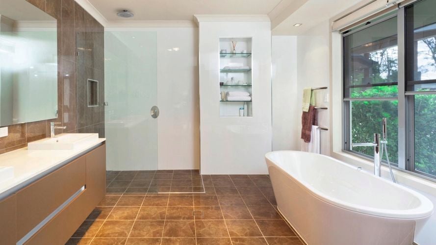 Bathroom with a mirror on the wall above a wooden cabinet with two basins on top of it.