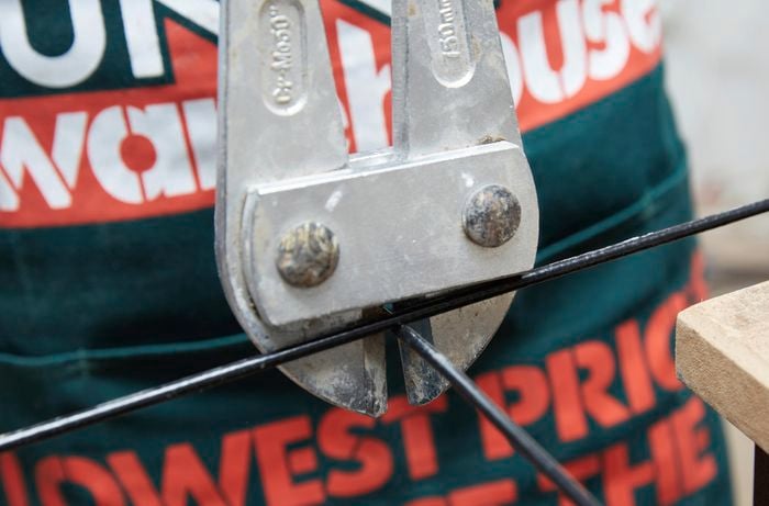 Wire mesh being cut with a pair of bolt cutters