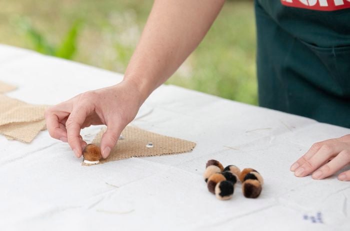 gluing pom poms onto hessian reindeer