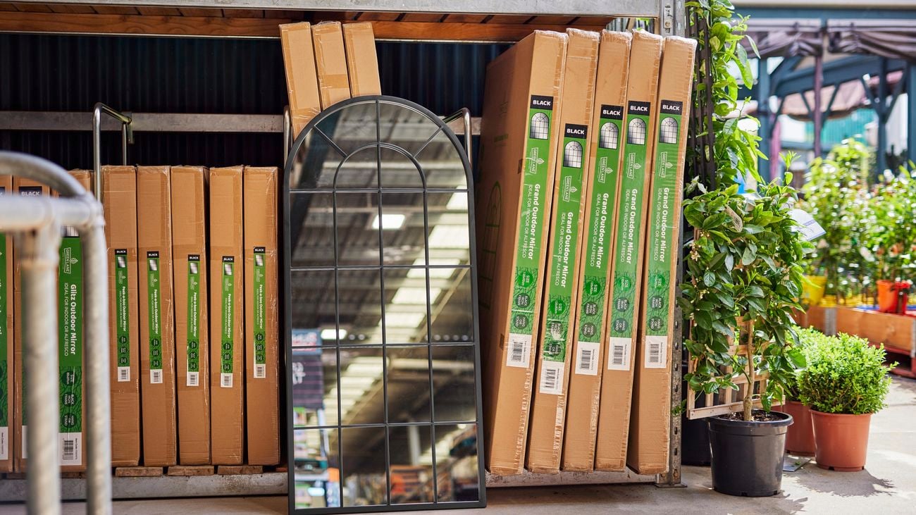 A mirror sitting in front of boxes with mirrors in them outside