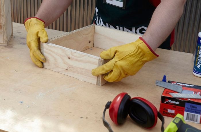Person assembling pieces of timber into rectangle