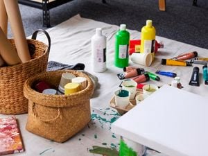 Paint pots, tubes and bottles sprawled across canvas dropsheet