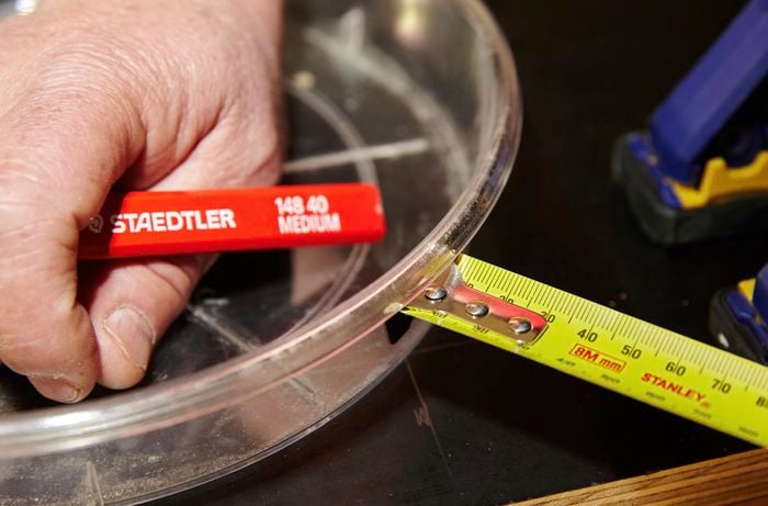 A person measuring the distance from a feeding bowl