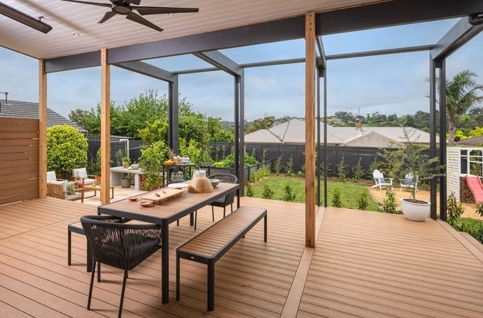 Outdoor entertaining area with a table and chairs in it