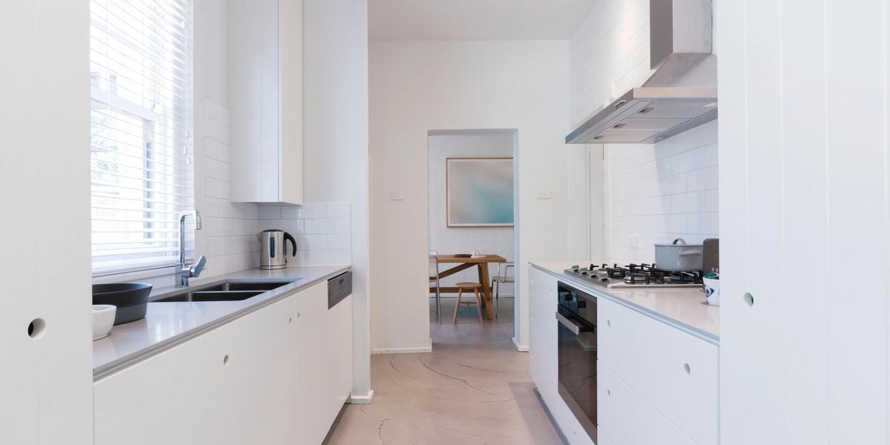 Kitchen with marble benchtops, two sinks and a stainless steel stovetop