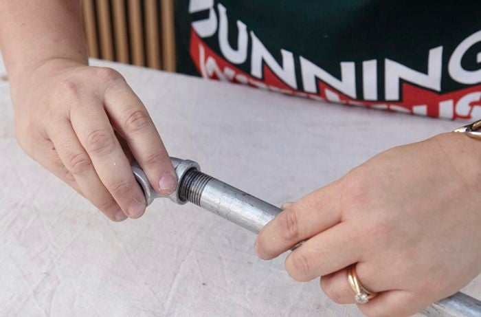 A pipe corner being screwed onto a length of pipe