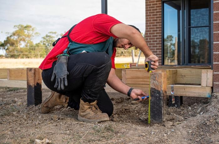 A Bunnings team member checking the height of a stump for a step