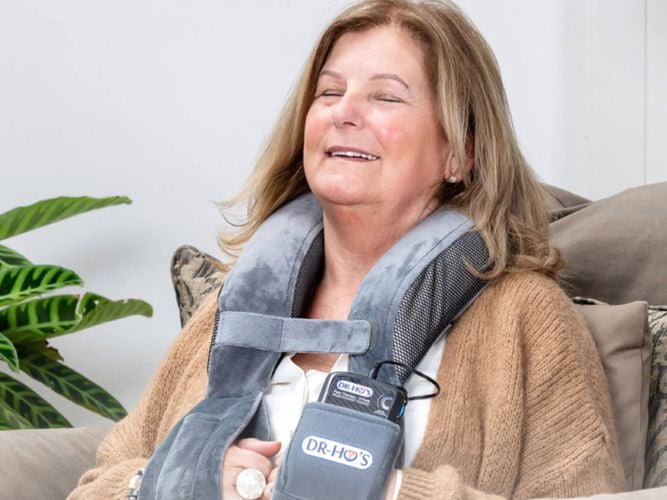 A lady with a Dr-Hos Neck Pain Pro, is the TENS + EMS device that provides fast relief for tension headaches and pain related to sore achy muscles in neck and shoulders.