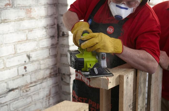 A corner of part of a wooden pallet being cut free by a Bunnings team member