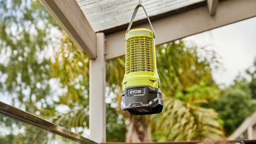 A Zapper lantern hanging from a hook in an outdoor space.