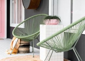 The finished tiled table between two lounge chairs holding a small plant pot