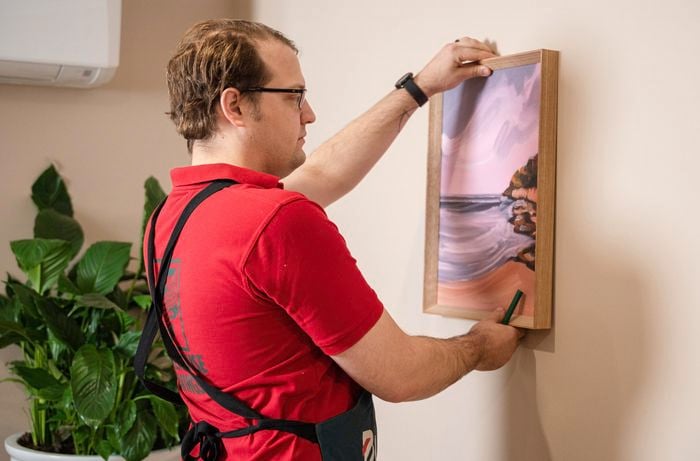 A Bunnings Team Member holding a picture against a wall