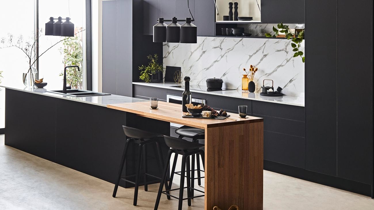 Kitchen with black cabinets and timber benchtops.