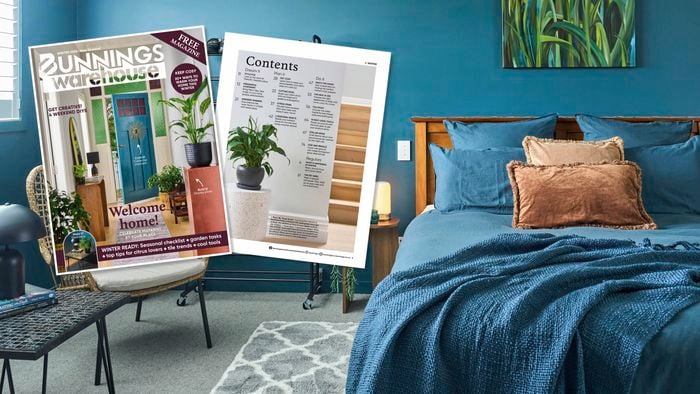 Styled bedroom with teal walls, wooden bed, and cushions, alongside Bunnings Warehouse Winter 2026 magazine cover and contents page displayed on a chair.
