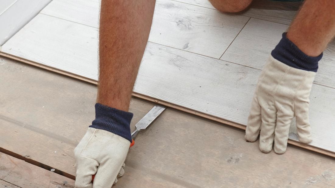 Laminate flooring being pulled up with a chisel