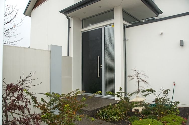 Exterior of a white townhouse with a dark grey front door