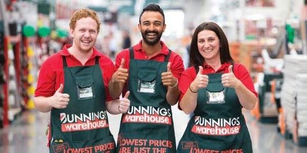 Three Bunnings Team Members smiling with their thumbs up.