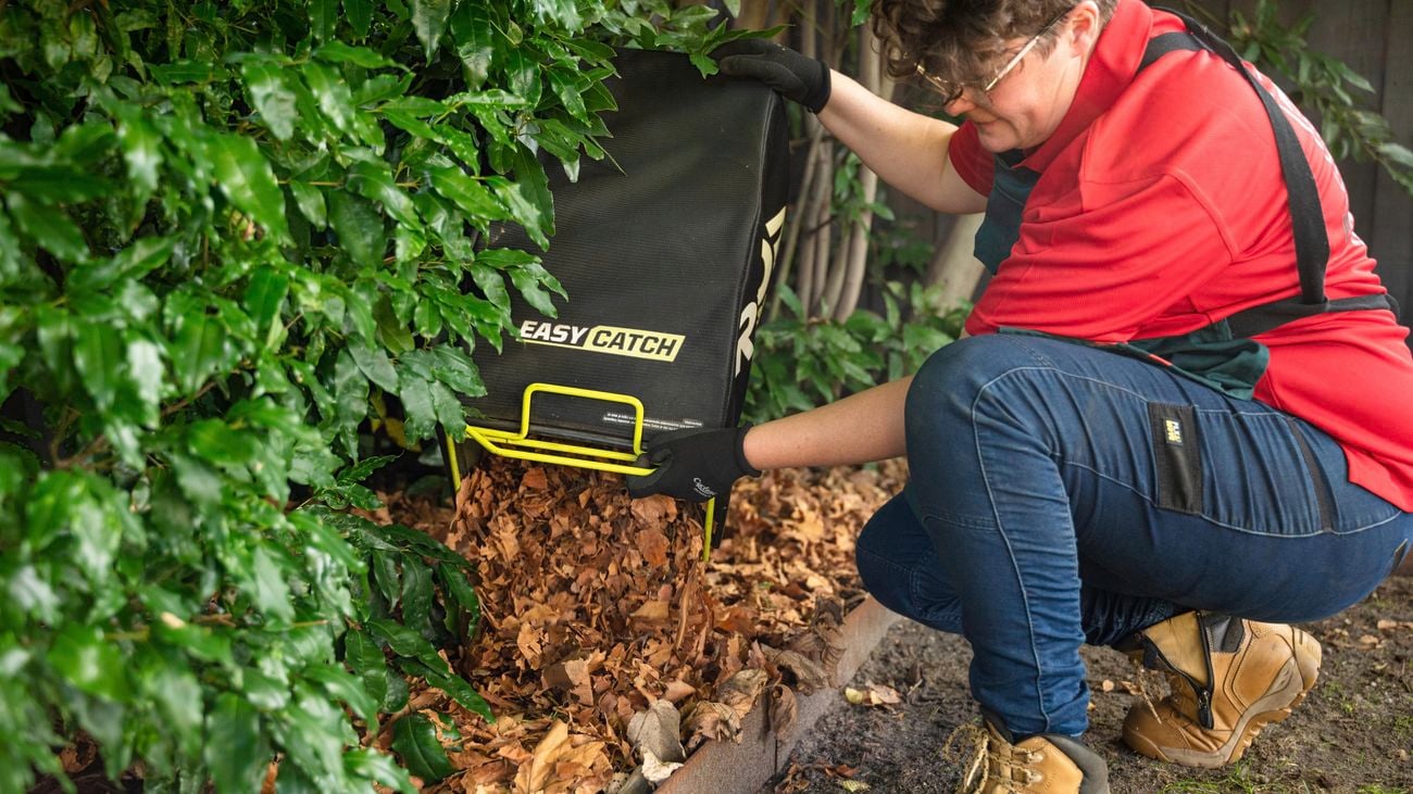 Adding plant leaves to garden bed.