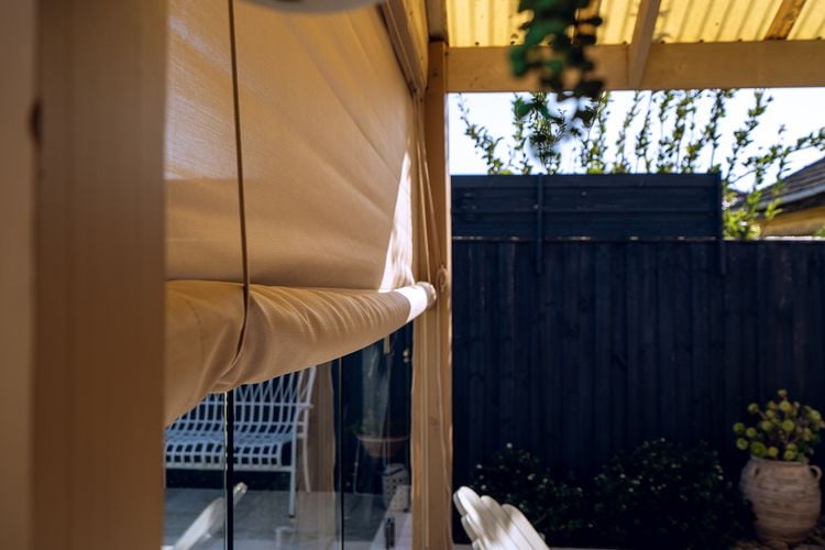 Outdoor timber decking area with roll-up blinds