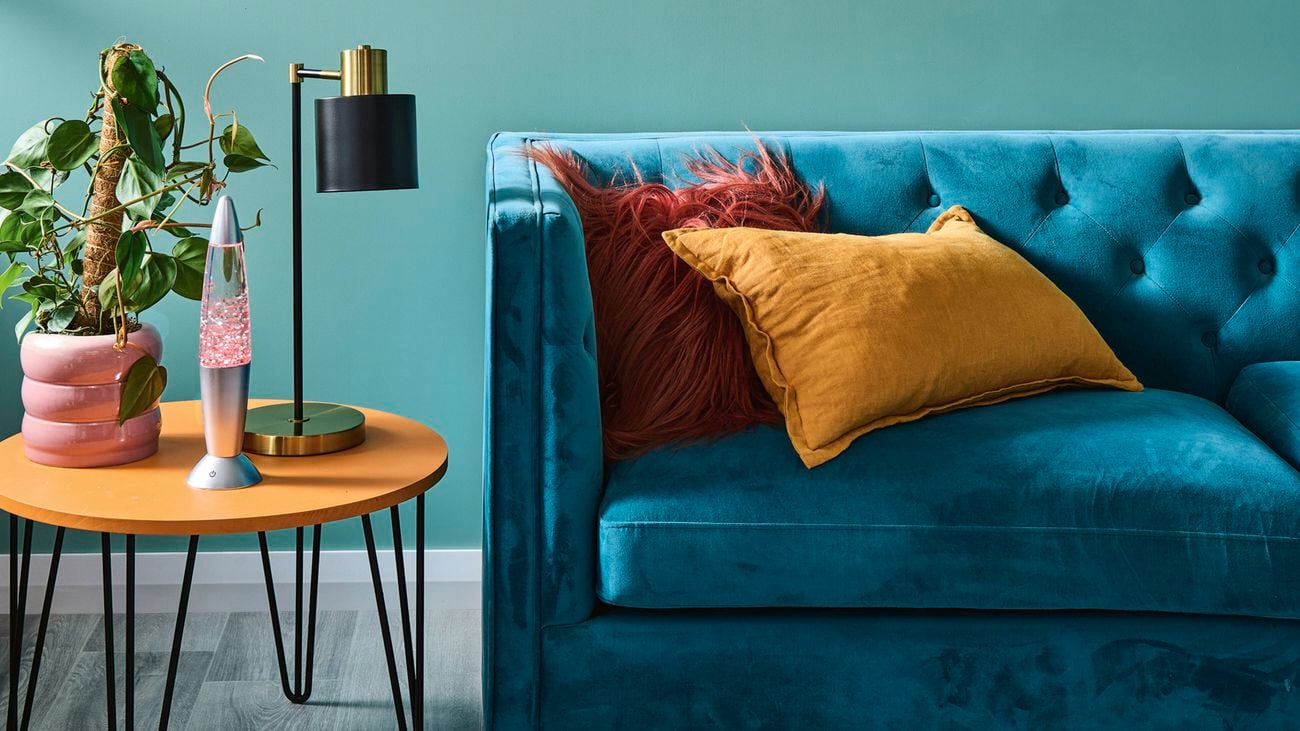 A D.I.Y. timber side table sits next to a blue velvet lounge