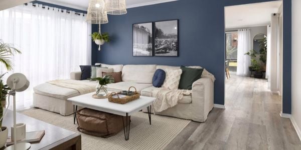 Lounge room with blue feature wall, white couch and white coffee table.