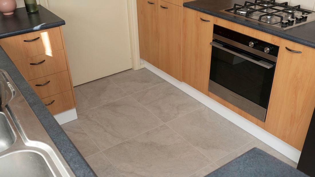 A kitchen with new gray tiles