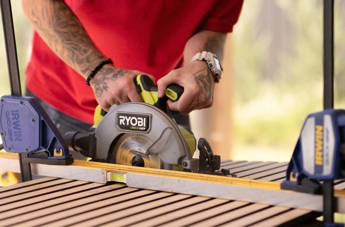 A person is using a circular saw to cut timber.