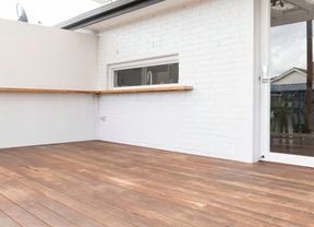 An image of the back of the house featuring a clean timber deck.