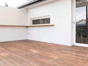An image of the back of the house featuring a clean timber deck.