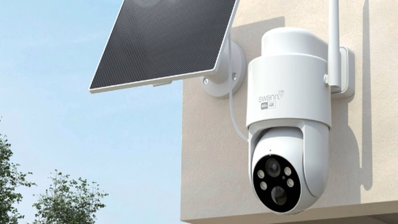 Outdoor security camera with attached solar panel mounted on a wall.