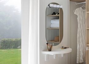 A makeup vanity table situated near an open wardrobe
