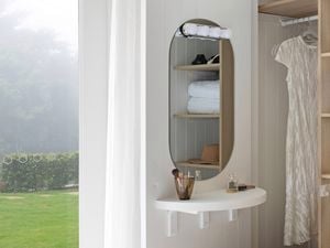 A makeup vanity table situated near an open wardrobe
