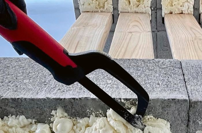 Mini hacksaw used to remove excess expanding foam