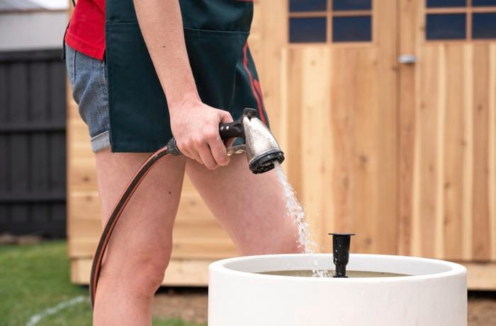 A Bunnings Team Member putting water into a water feature
