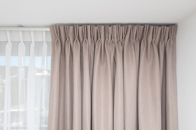 Detail of fabric curtain on a track next to sheer curtain