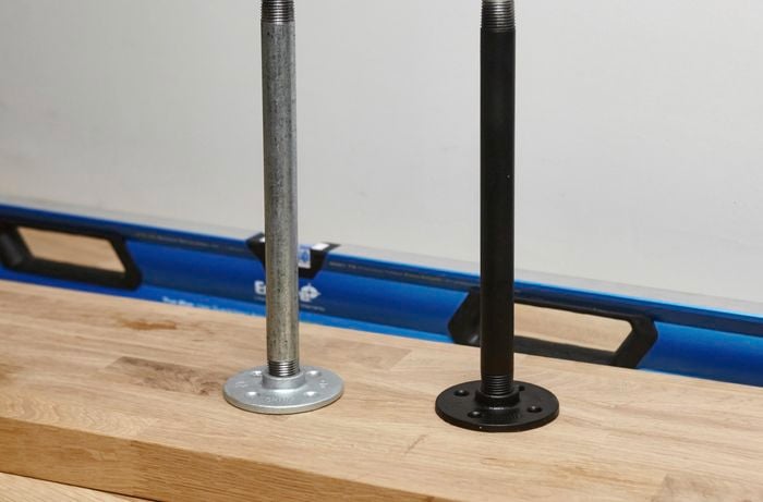 Two metal pipe shelf supports, one spray painted black