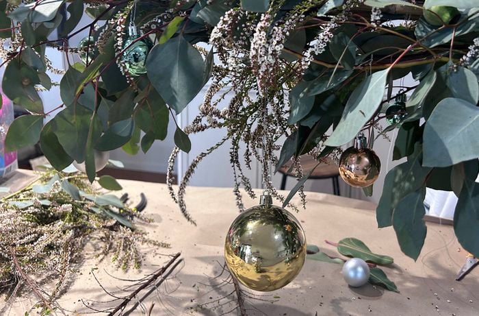 Tying baubles to a Christmas chandelier