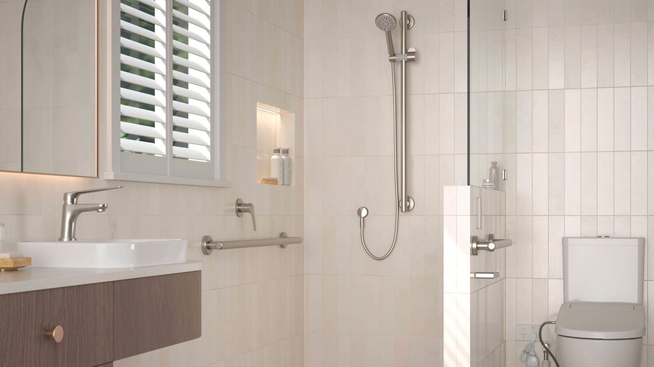 Modern accessible bathroom with walk-in shower, grab rails, and toilet.