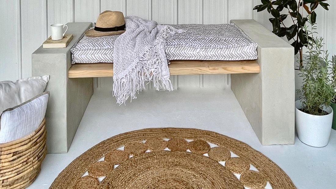 Block bench with timber slats, hat, rug and plant