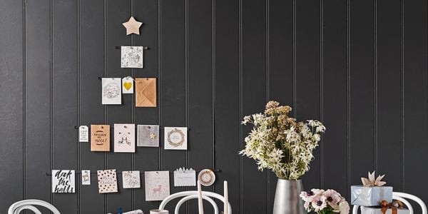 Christmas cards arranged in the shape of a tree on a wall