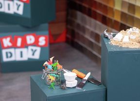 A pile of sand with toy dinosaurs and plaster fossils, accompanied by excavation tools.] 