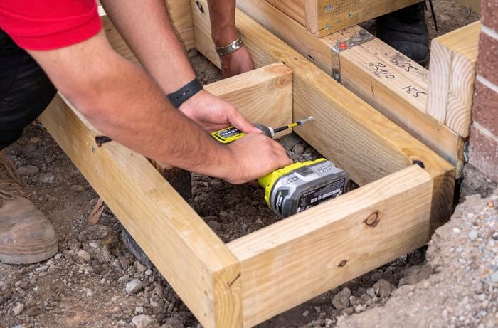 A subfloor being screwed into place on a deck
