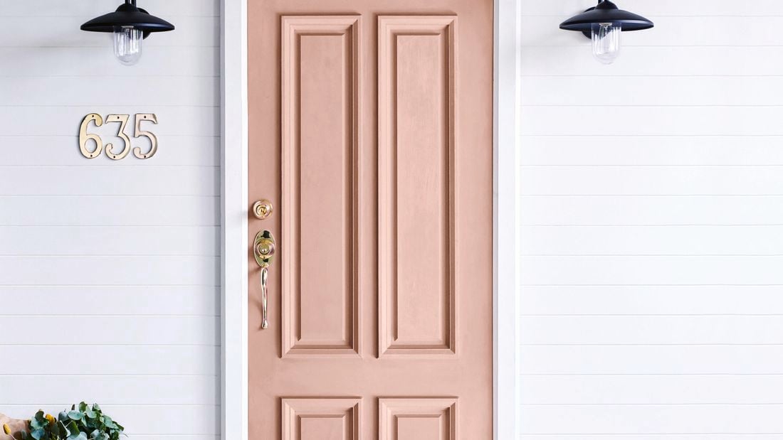 Light brown entrance door with brass locks and handle.