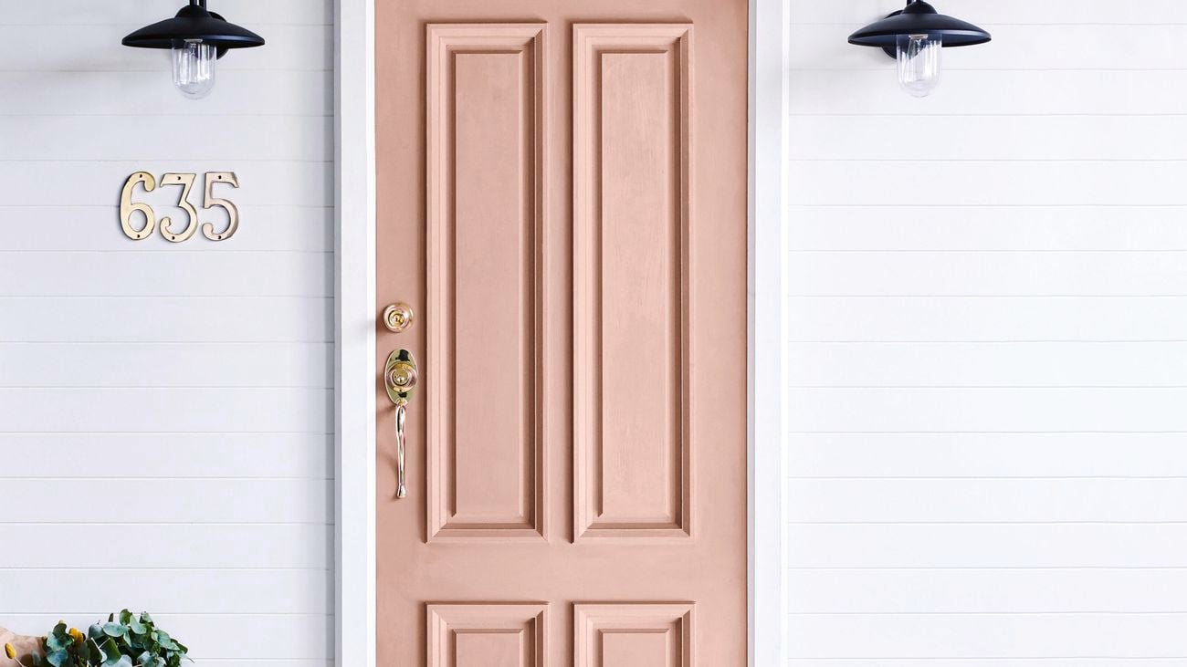 Light brown entrance door with brass locks and handle.
