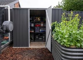 Shed with opened door and organised products on shelving units.