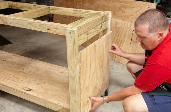 Person putting side of DIY portable workbench in place.