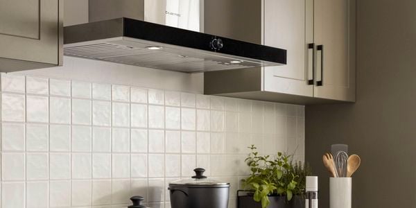 Modern kitchen with rangehood and kitchenware.