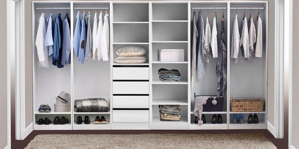 A walk in wardrobe with clothes and shoes in it