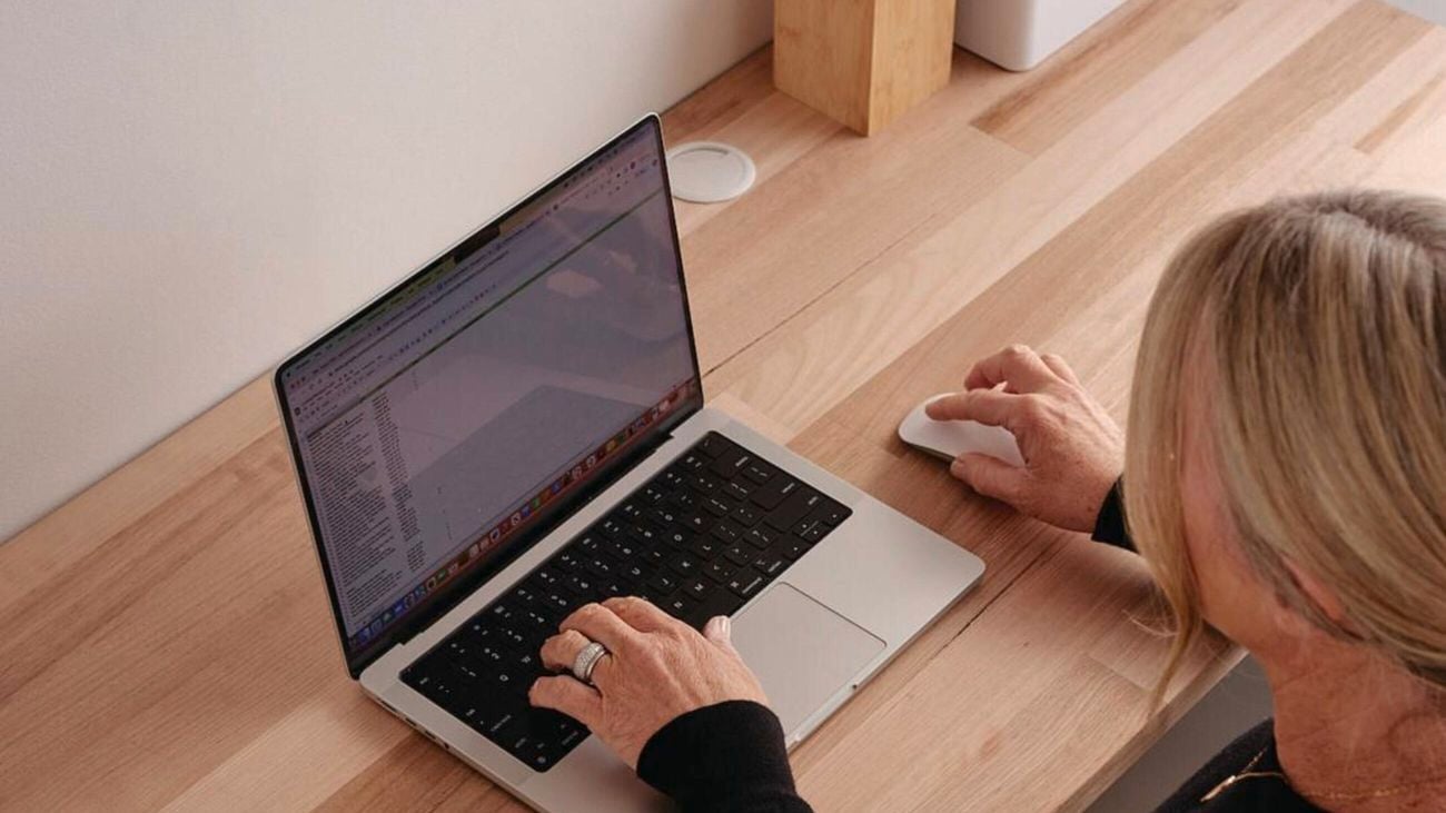 Overhead shot of woman sitting at study desk, typing on laptop.