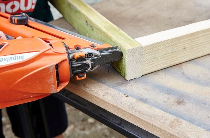 Framing gun putting two timbers together.